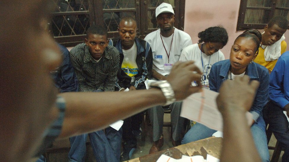 An official raises a used ballot paper while counting votes during an election in the Democratic Republic of Congo, 29 October 2024